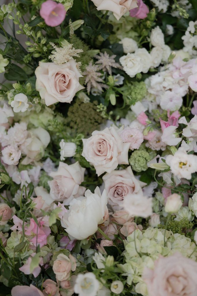 14-tier sculptural wedding cake at Saltmarshe Hall surrounded by blush and ivory wedding flowers