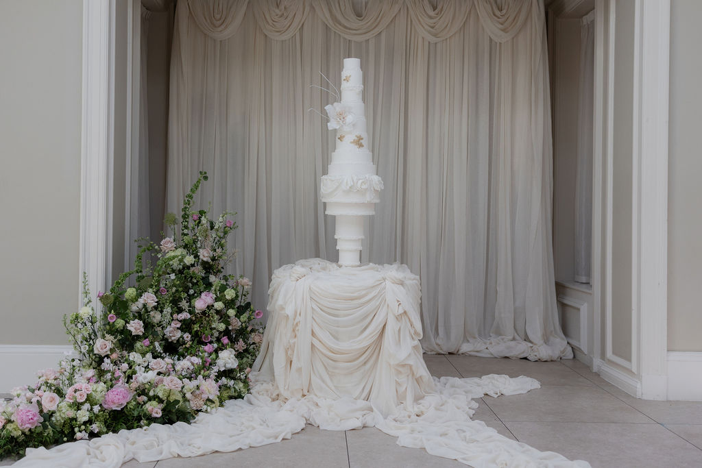 14-tier sculptural wedding cake at Saltmarshe Hall surrounded by blush and ivory wedding flowers